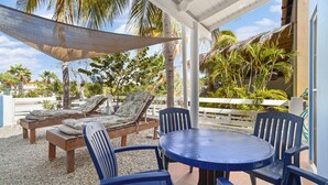A covered outdoor seating area with lounge chairs and a table. - Your Place In Paradise! Just steps to private dive beach and resort pool (Kralendijk)