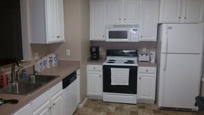 A kitchen with white cabinets, a stove, a microwave, a refrigerator, and a sink. - Blue Ridge Beauty Home Dog Friendly, Walk to Rivers, A.T. Trail, & HF. NEW LVP (Bolivar)