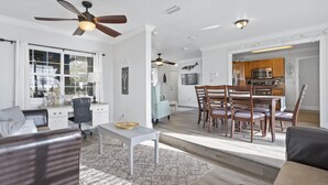 A spacious living room with a dining area, a kitchen in the background, and a ceiling fan. - Finley House with Beautiful Gulf View (Gulfport)
