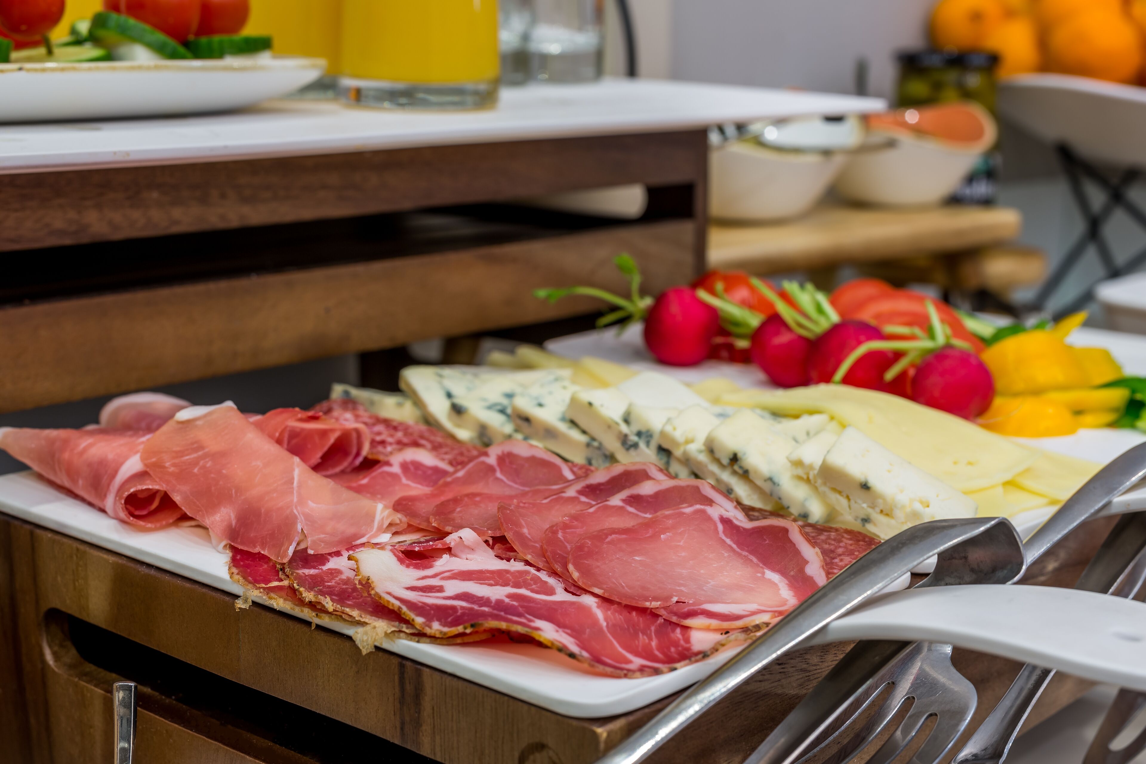 Una mesa con diversos alimentos, incluyendo fiambres y quesos.