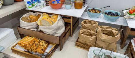 A buffet setup with various food items and condiments.