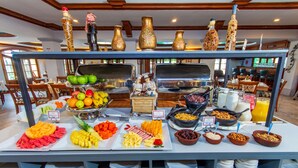 A buffet with various food items and a kitchen area in the background. - Hotel Rincon de Puembo, BW Signature Collection (Puembo)