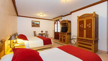 A hotel room with two beds, a wooden wardrobe, a television, and a painting on the wall.