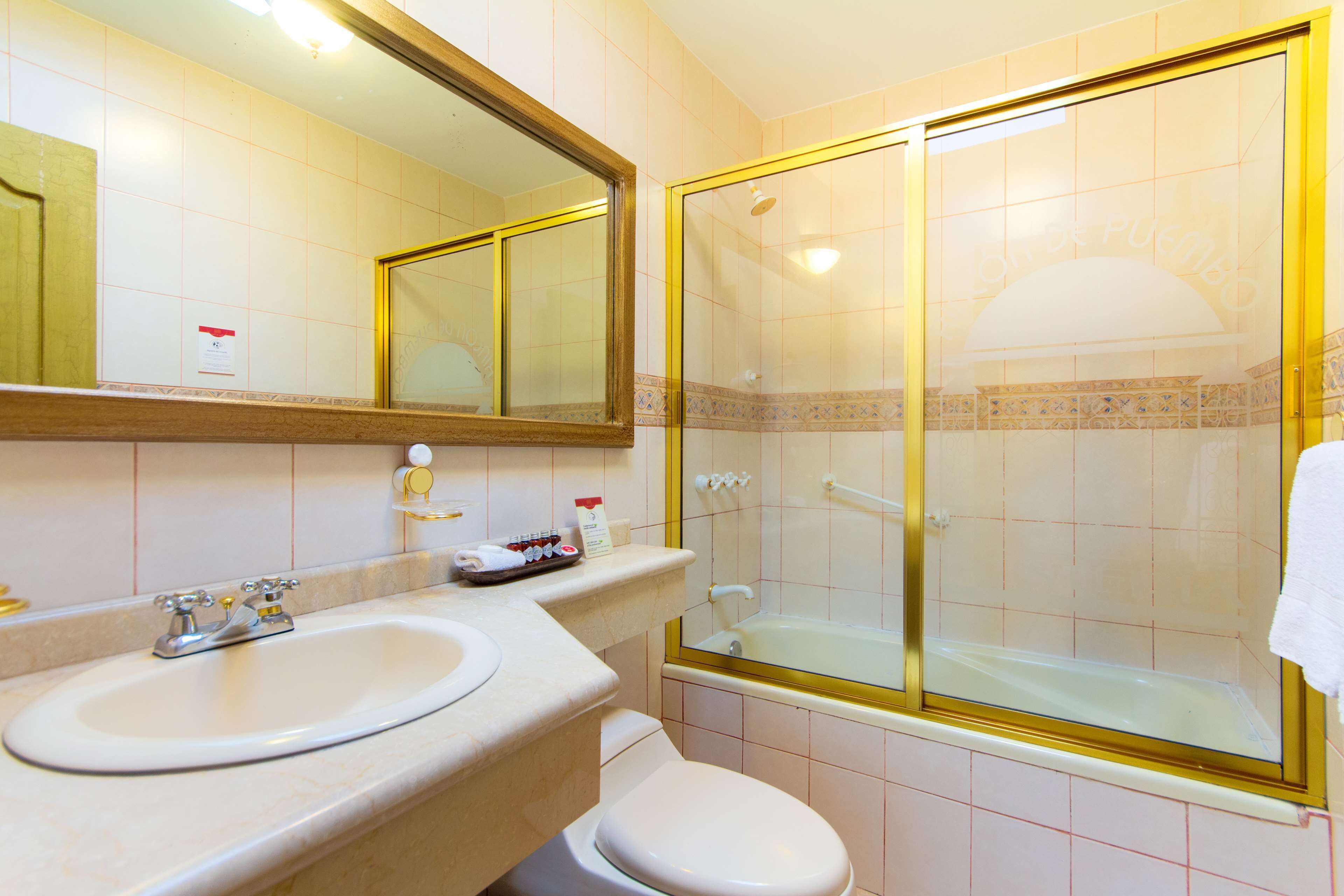 Un baño con lavamanos, inodoro y ducha con cerramiento de vidrio.