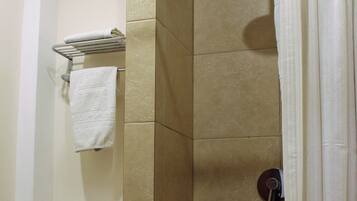 A bathroom with a shower, toilet, and towel rack.