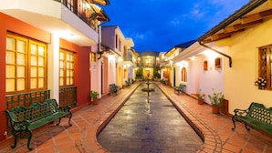 A courtyard with a fountain, benches, and potted plants. - Hotel Rincon de Puembo, BW Signature Collection (Puembo)