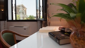 A room with a window, a radiator, a chair, a table with books and a vase. - Hotel Tessarin (Taglio di Po)