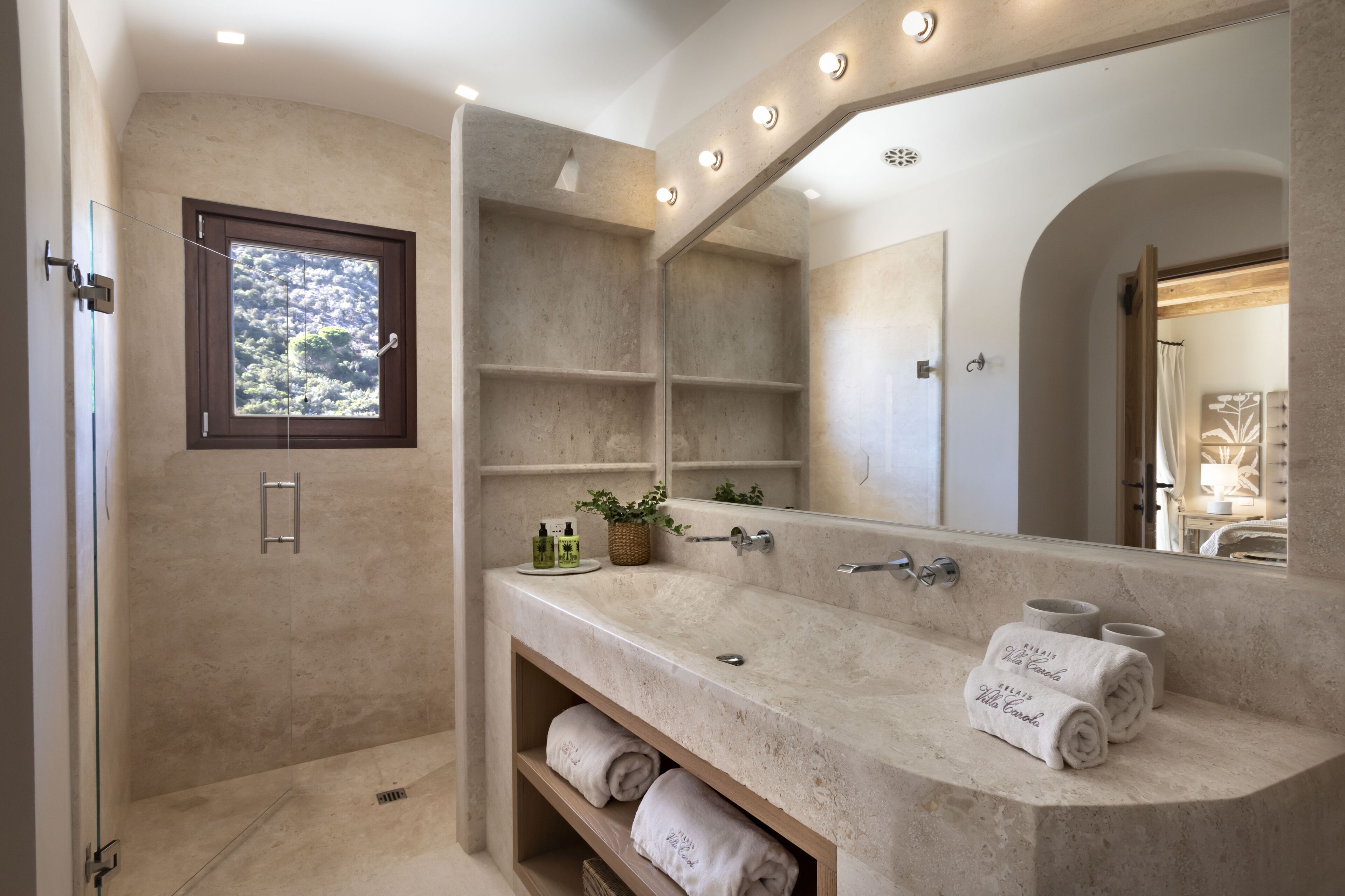 Un baño moderno con un espejo grande, una bañera y una zona de ducha.