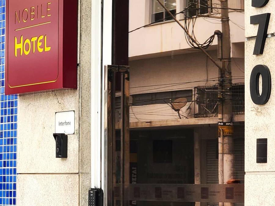 The entrance to a hotel with a glass door, a sign indicating it's a 'Noble Hotel', and the address '570' visible on the wall.