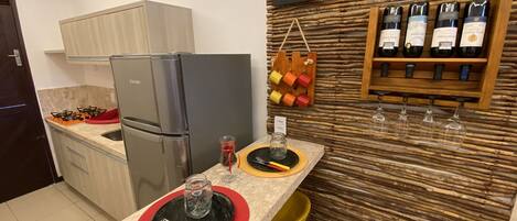 A modern kitchen with a built-in refrigerator, gas stove, and a wine rack on the wall.