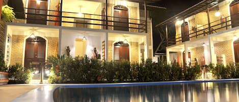 Una piscina al aire libre, sillones reclinables de piscina