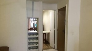 Un couloir mène à une cuisine dont l’espace repas est visible à travers une porte vitrée.