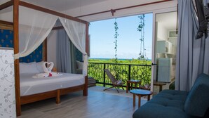 A bedroom with a four-poster bed, a balcony with a view, a sofa, and a small table. - Ocean Zen Suites on 5th Avenue - Adults Only (Playa del Carmen)