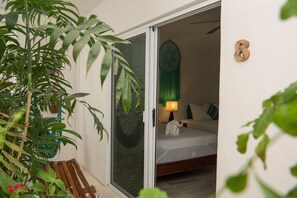 Une pièce avec un lit, une décoration murale verte et un banc en bois.