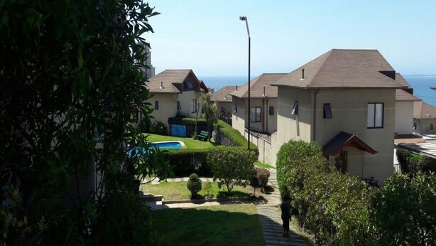 A residential area with houses, a swimming pool, and a clear view of the ocean. - House para 4 en Concon (Concon)