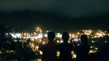 Silhouettes of people taking photos with a cityscape in the background.