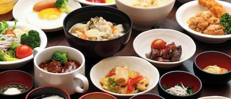 A variety of dishes arranged on a table, including a bowl of soup, a plate of fried chicken, and a bowl of rice.