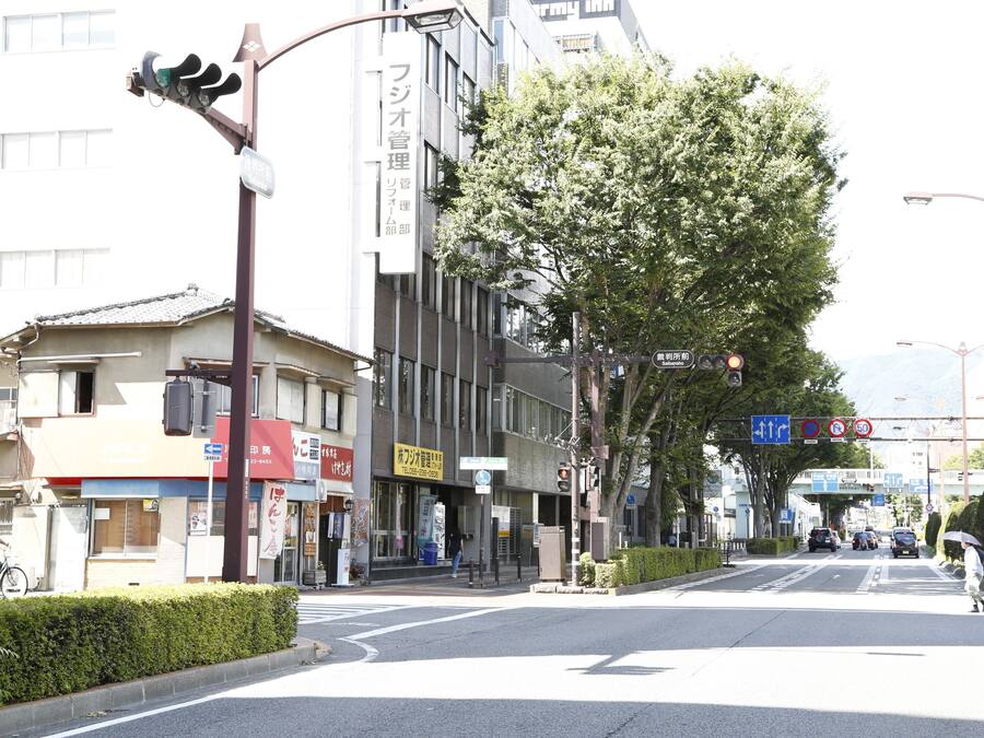 Una intersección de calles con edificios, un semáforo y un paso de peatones.