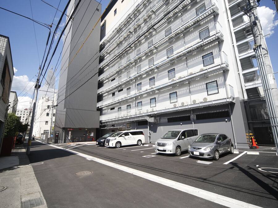 Un edificio de varios pisos con un área de estacionamiento al frente.