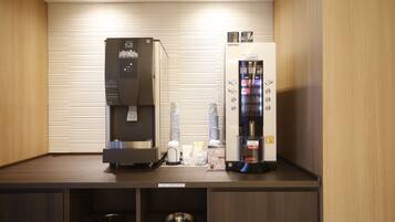 A kitchenette with a coffee machine, a water dispenser, and a refrigerator.