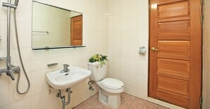 A bathroom with a sink, toilet, shower, and a wooden door. - The Areumdaun Pension (Seogwipo)