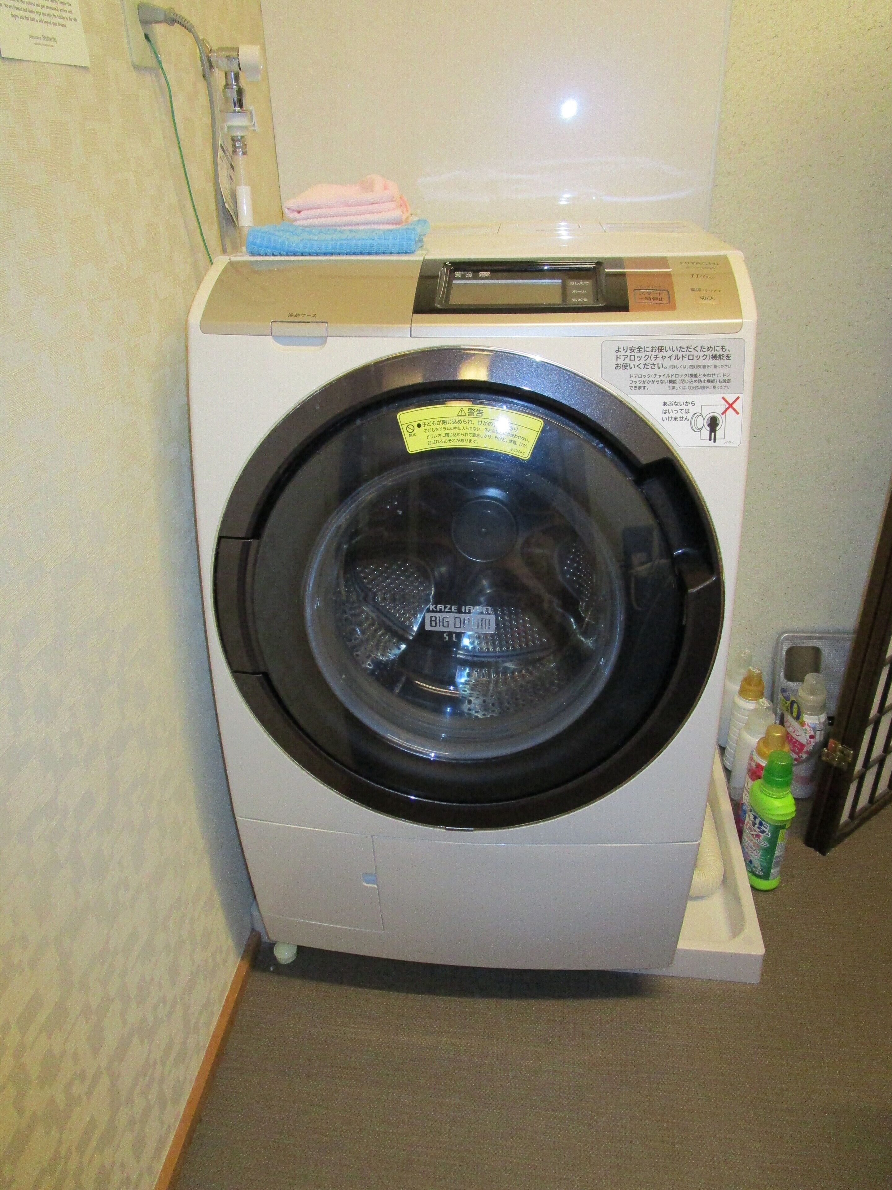 A front-loading washing machine in a hotel room.