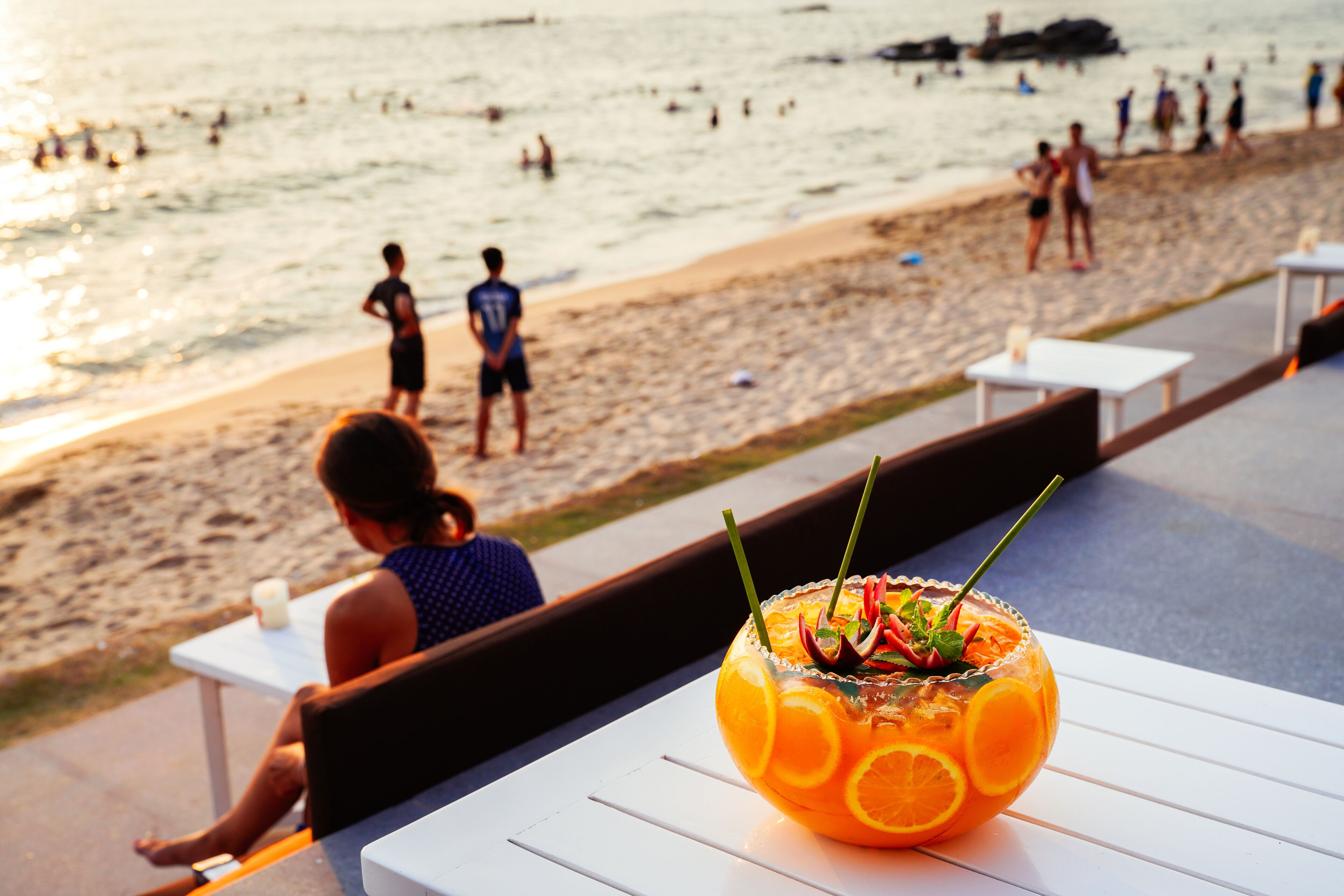 A beachside restaurant with outdoor seating overlooking the ocean.