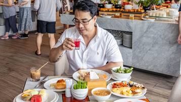 Un restaurante con una variedad de platos en las mesas, como ensaladas, carnes y postres.