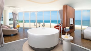 A modern hotel room with a large bathtub, a TV, and a view of the beach. - Seashells Hotel and Spa Phu Quoc (Phu Quoc)