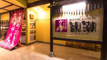 A traditional Japanese building with a signboard displaying Japanese characters.
