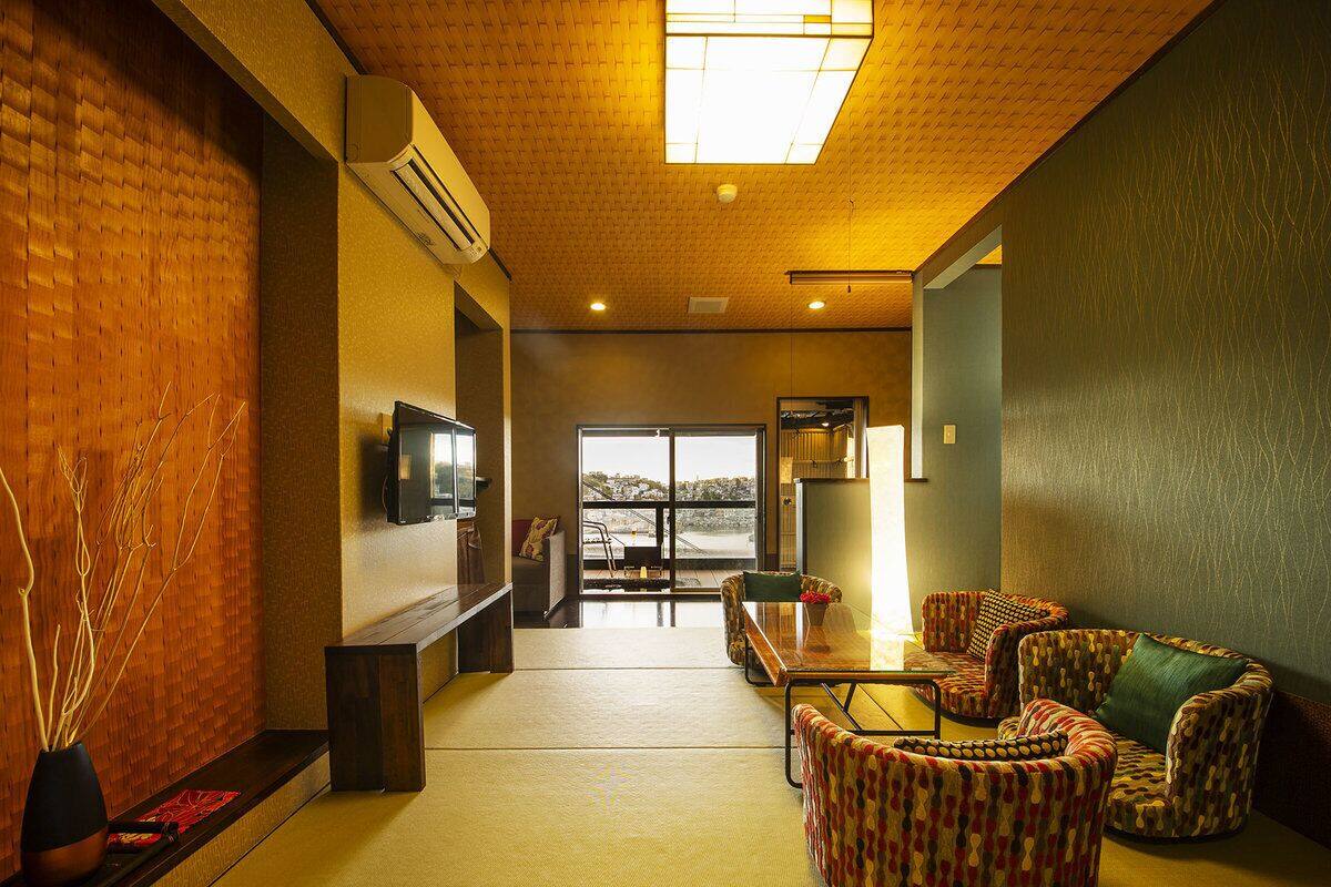 Un vestíbulo de hotel con una recepción, zona de estar y grandes ventanales con vistas.