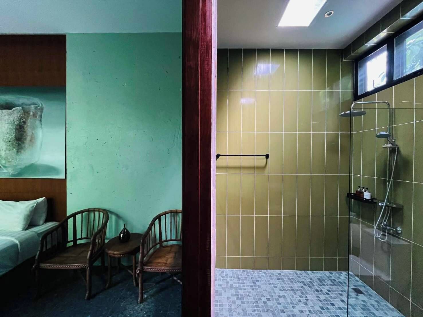 Un baño con ducha, un perchero y un estante pequeño con artículos de aseo.