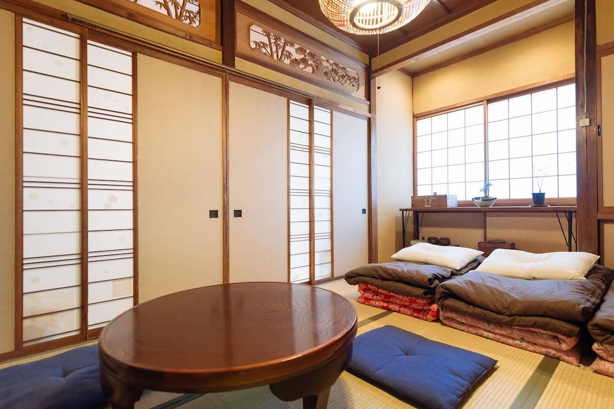 Een traditionele Japanse kamer met tatami vloerbedekking, een lage houten tafel en shoji schermen.
