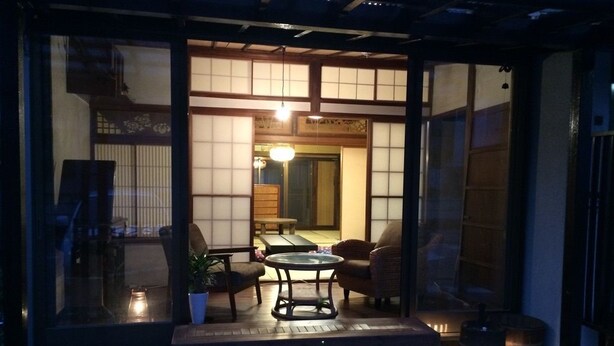 A traditional Japanese-style room with tatami flooring, a low table, and a sofa. - Guest house Enishi - Hostel (Toyama)
