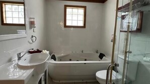 Een badkamer met bad, toilet en wastafel.