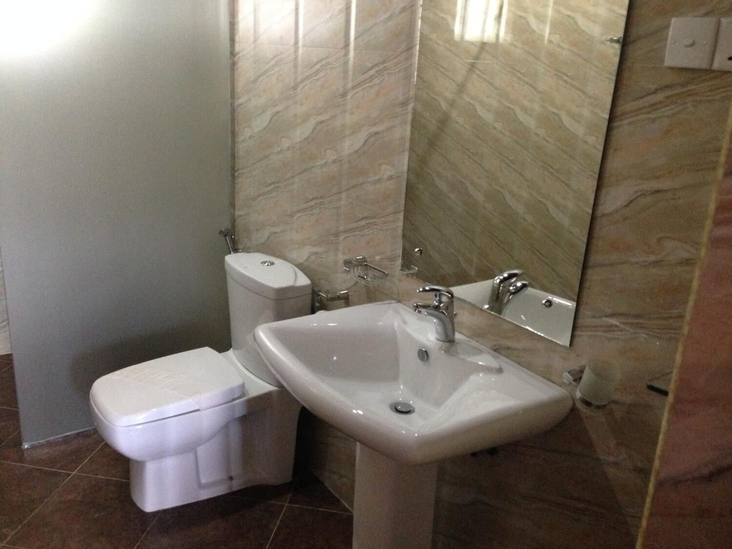 Ein Badezimmer mit Toilette, Waschbecken und Spiegel.