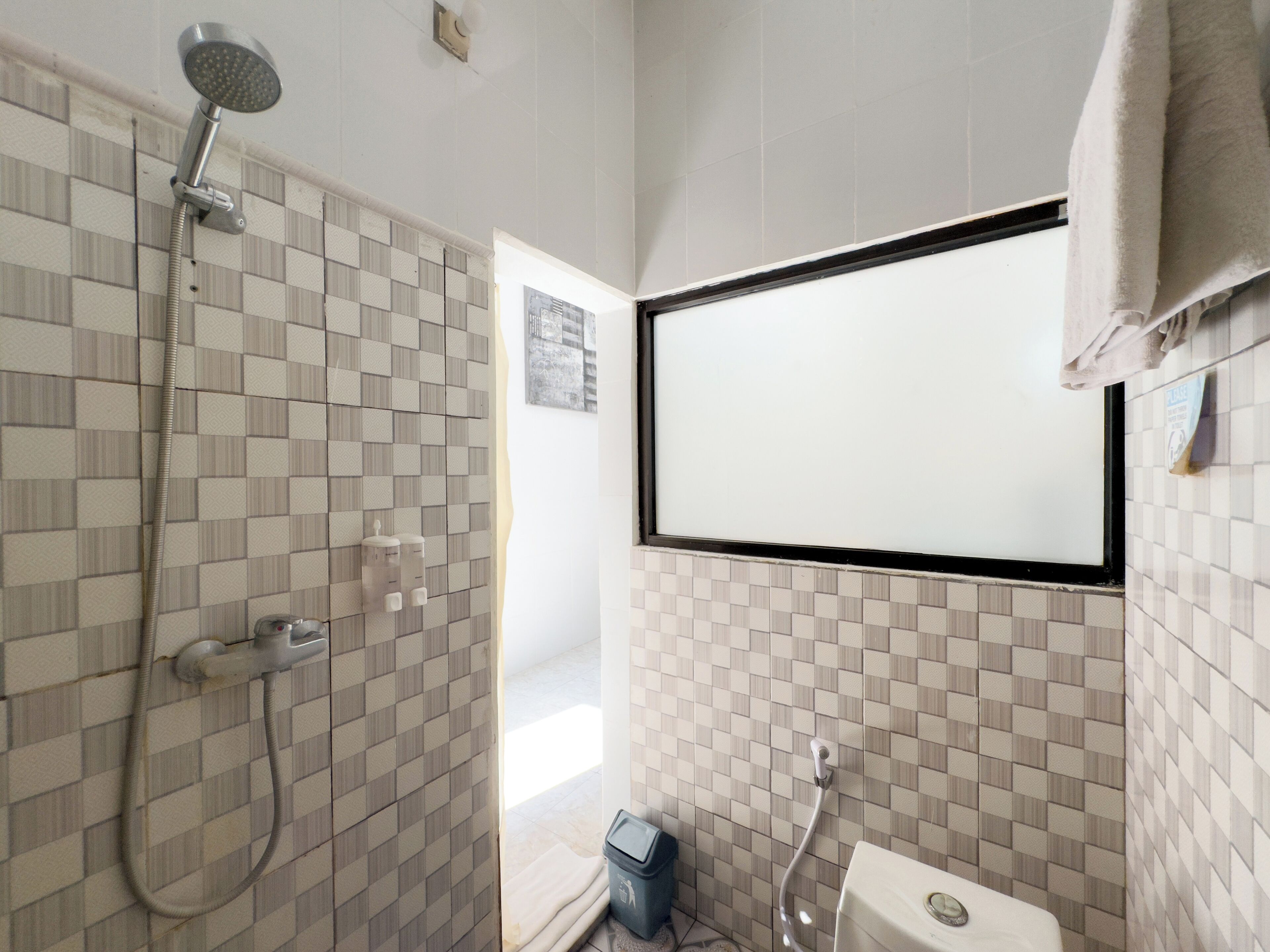Een badkamer met een douche, toilet en wastafel.