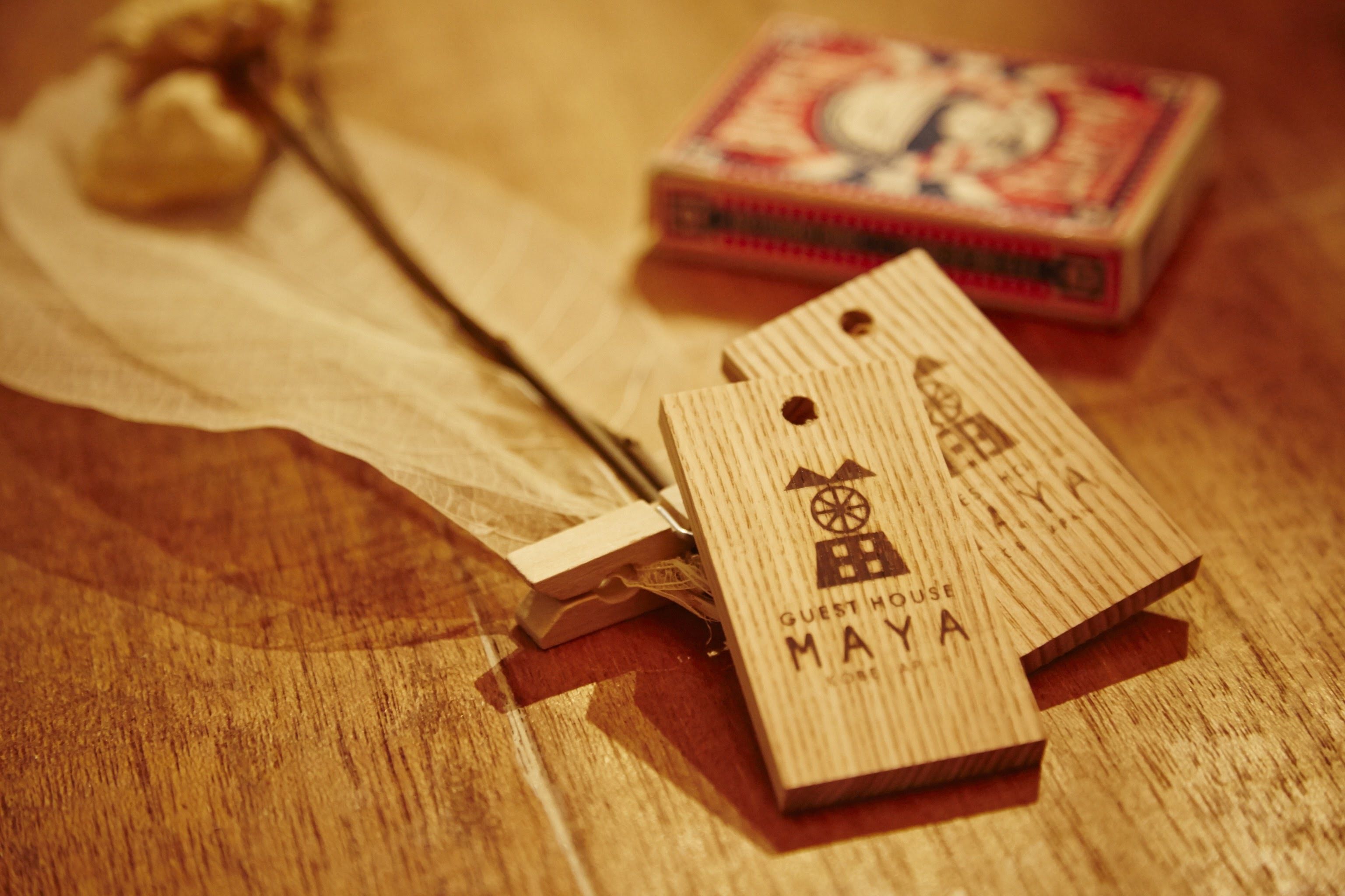 Etiquetas de madera con texto y una pequeña caja sobre superficie de madera.