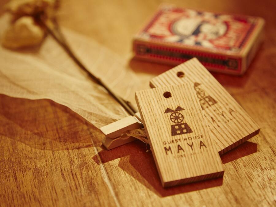 Etiquetas de madera con texto y una pequeña caja sobre superficie de madera.