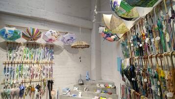 A room with multiple hanging umbrellas and a variety of items displayed on shelves and tables.