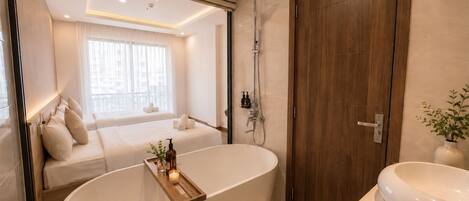 A modern bathroom with a freestanding bathtub, a wooden vanity, and a shower area.