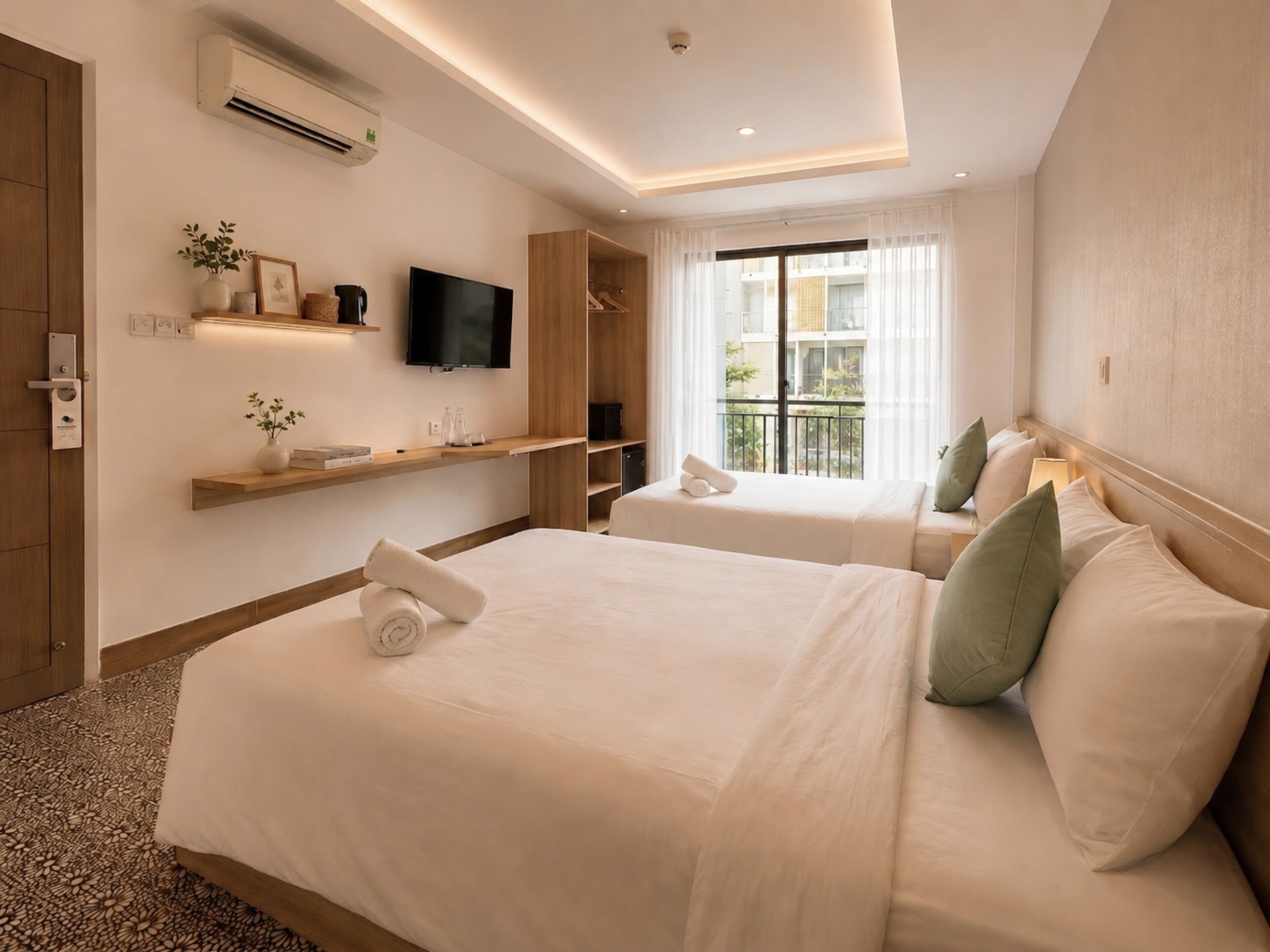 A hotel room with two beds, a television, a window with curtains, and a built-in wardrobe.