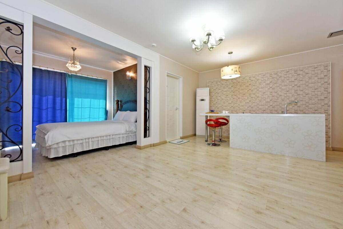 Ein modernes Schlafzimmer mit Bett, ein Badezimmer mit Waschbecken und eine Küchenzeile.