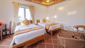 A hotel room with two beds, a wooden ceiling, a dining table with chairs, and a window with curtains. - Ly Phuc Homestay (Da Nang)