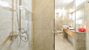 A modern bathroom with a glass-enclosed shower, a marble-tiled floor, a wooden vanity, and a large mirror. - Ly Phuc Homestay (Da Nang)