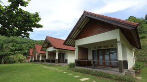 A row of modern villas with red-tiled roofs, large windows, and a well-maintained lawn. - Artati Lombok Bungalows & Restaurant (Selong Belanak)