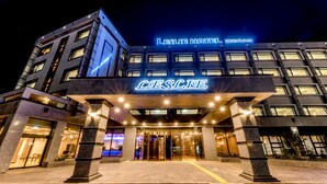 Un hôtel moderne, reconnaissable à son enseigne bien visible « LESLIE HOTEL », doté d’une entrée bien éclairée et d’une façade structurée avec de nombreuses fenêtres.
