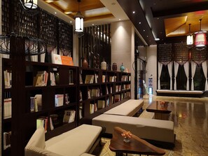 A modern library with bookshelves, seating areas, and decorative lighting. - Relaxed Season Hotel - Foshan (Foshan)