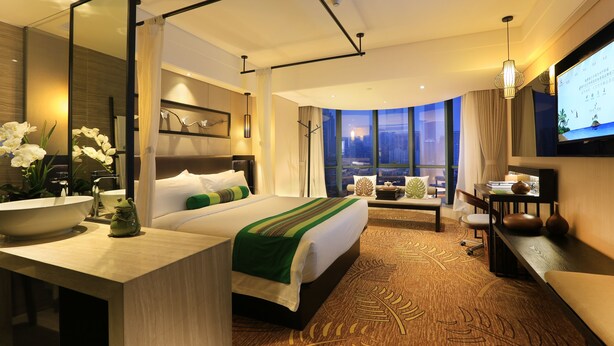 A hotel room with a large bed, a desk with a bowl sink, a TV, and a view of the cityscape. - Relaxed Season Hotel - Foshan (Foshan)