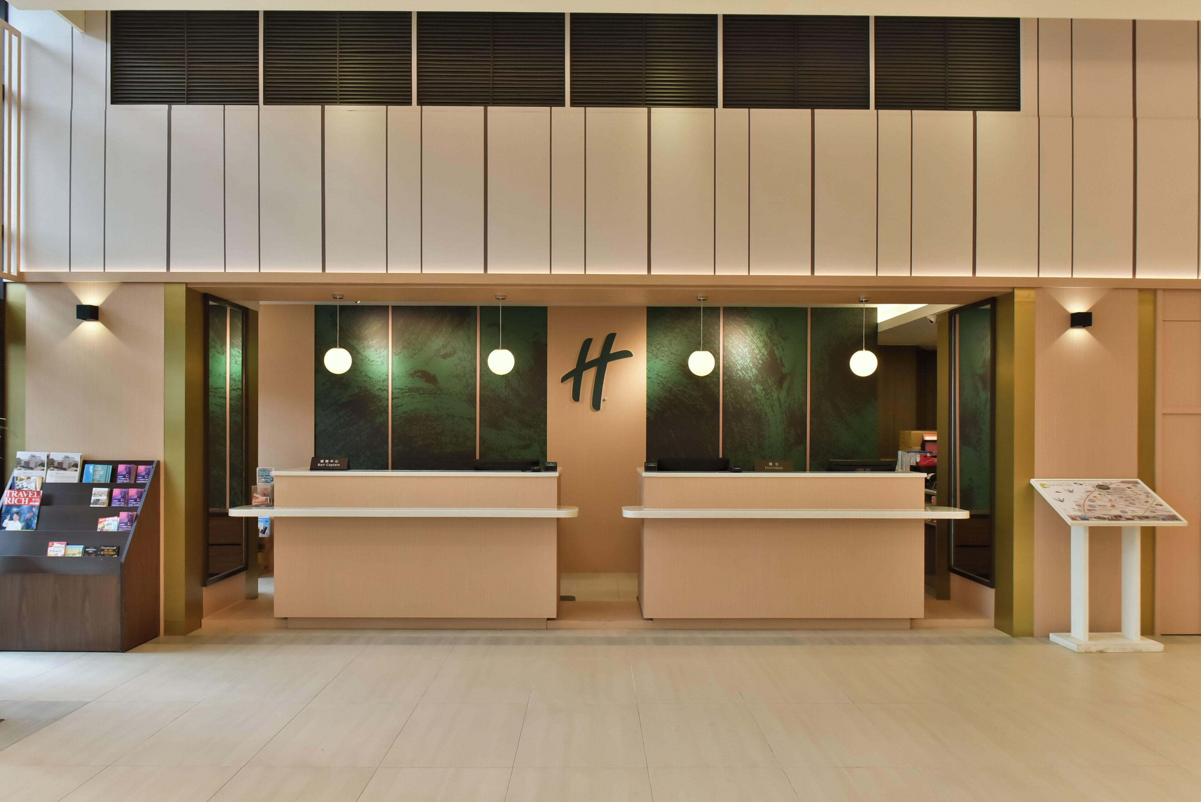 A reception area with two counters, a wall-mounted sign, and a display stand with brochures.